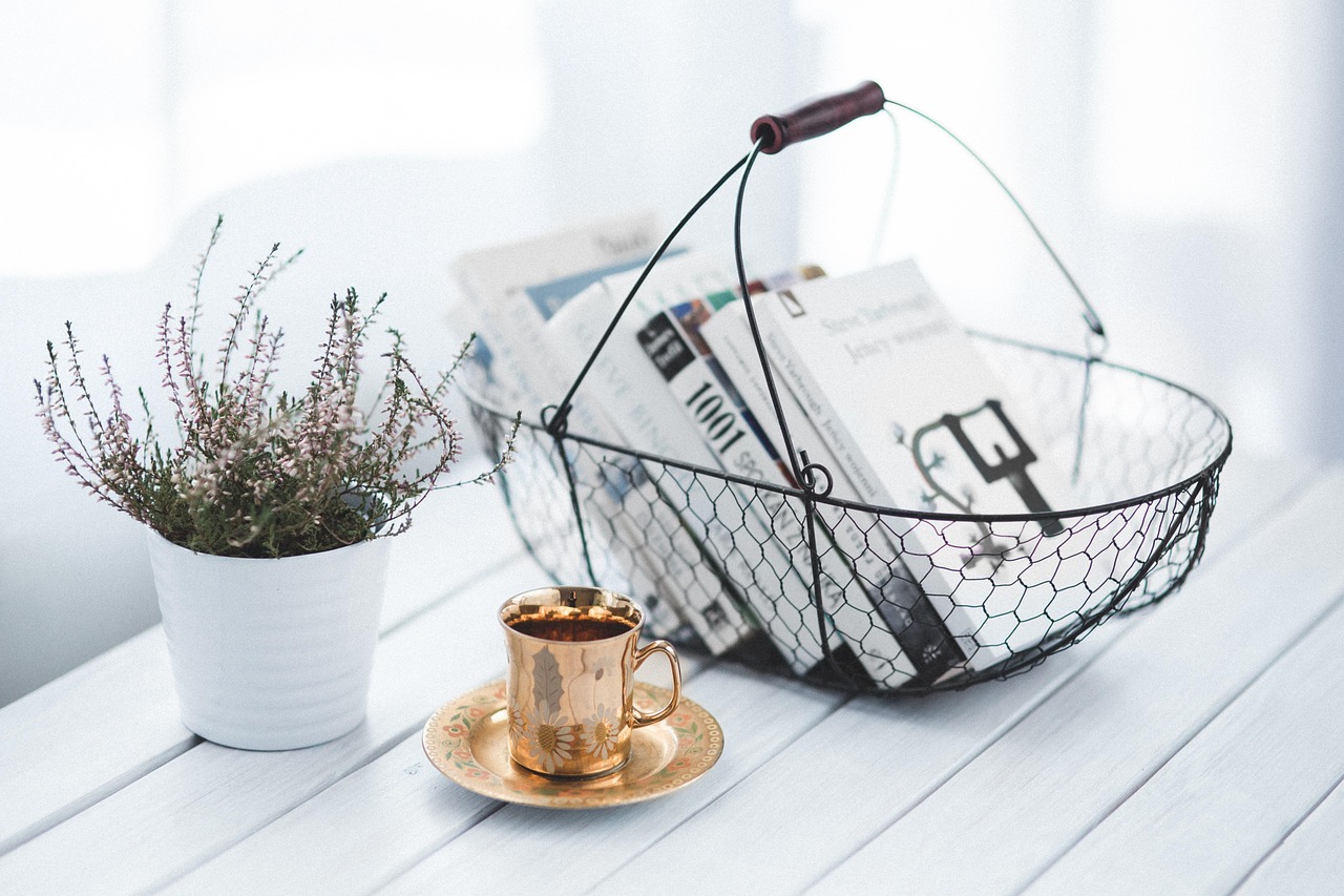 Make Your Bed book review - books in a wire basket with a cup of coffee and a small plant