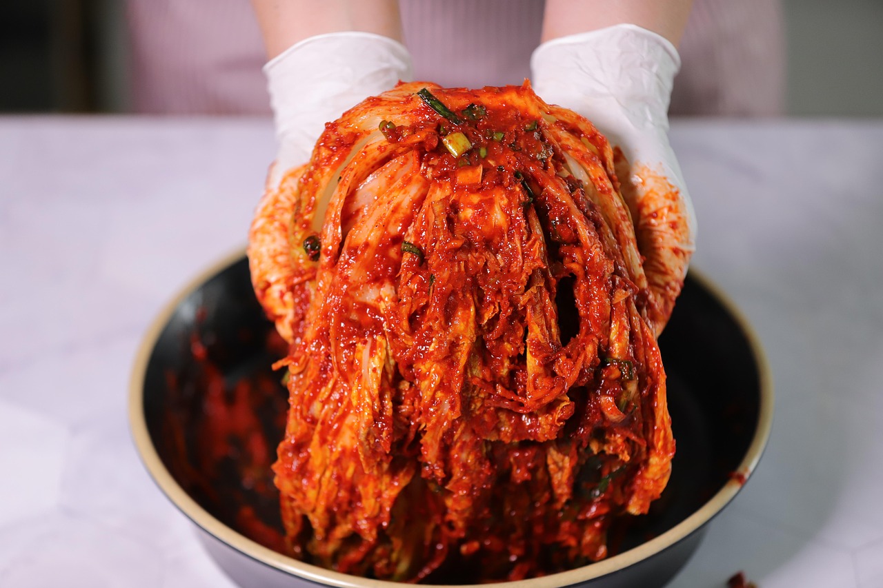Homemade kimchi — freshly seasoned napa cabbage kimchi held over a bowl