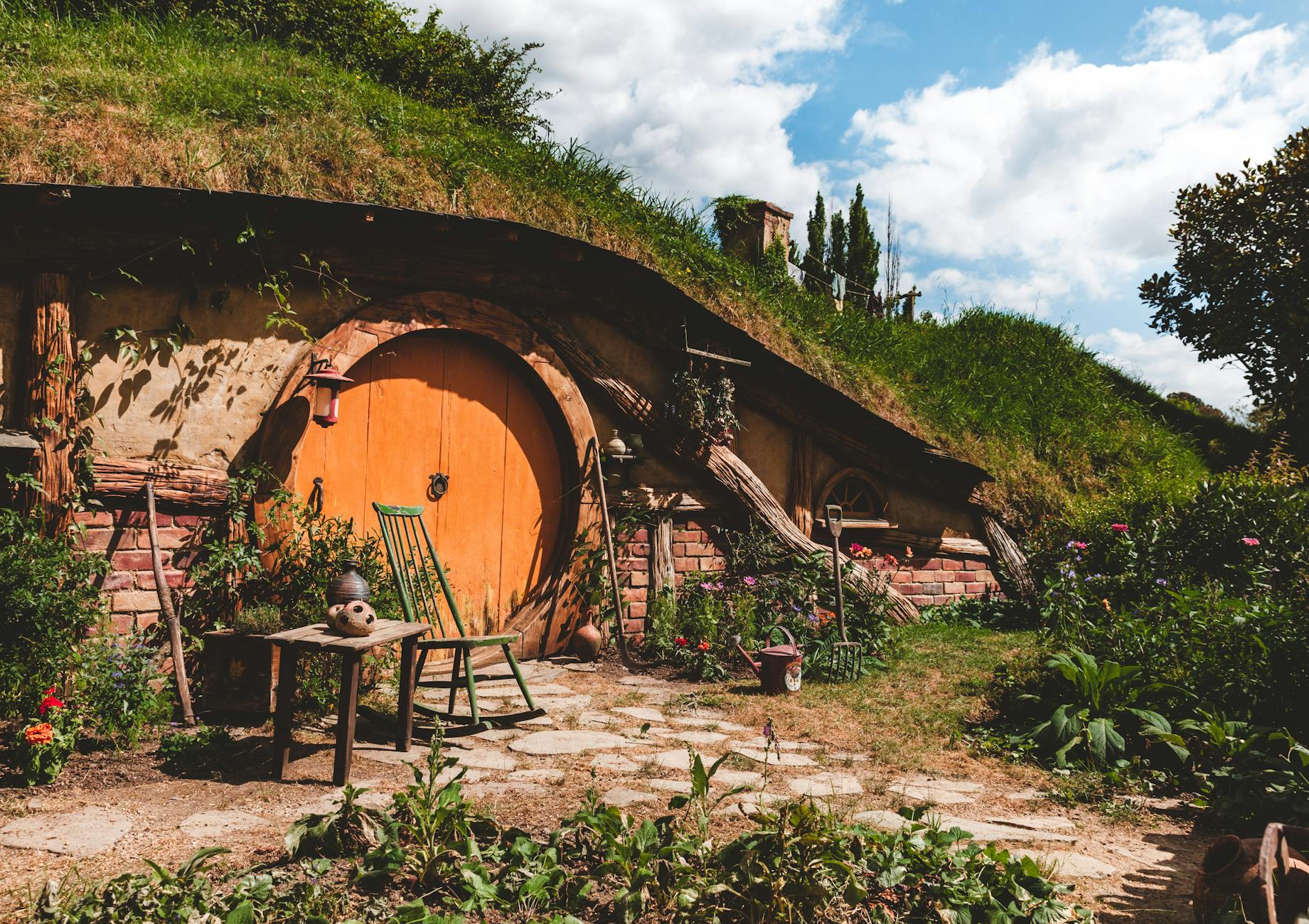 New Zealand in March - Hobbit hole with a round orange door at Hobbiton, Matamata