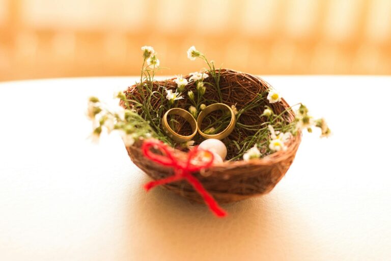 Two wedding rings resting in a small flower nest, symbolizing an online dating love story that led from swiping right to saying I do
