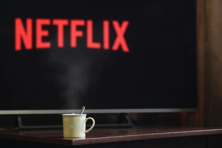 Black Mirror White Christmas – television showing Netflix with a cup in front of it