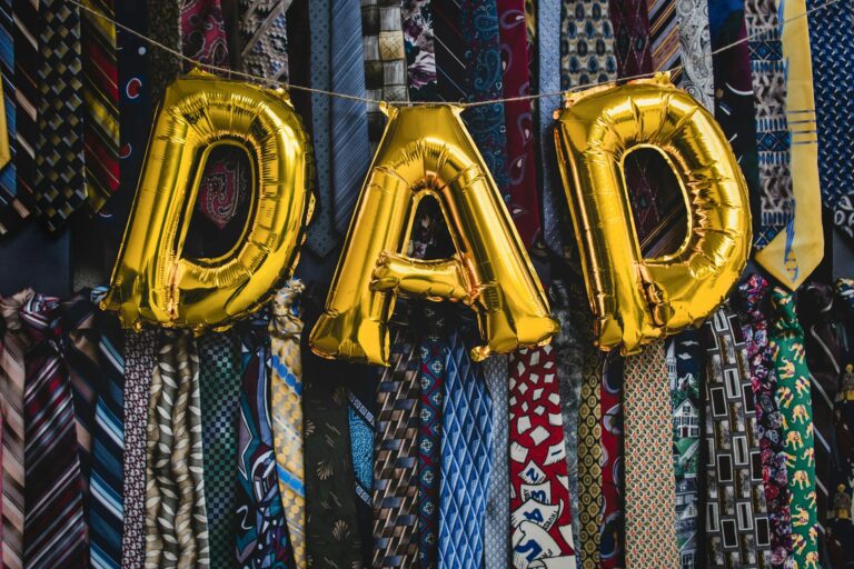 Strong Fathers Strong Daughters - golden letter balloons forming the word DAD in front of neckties