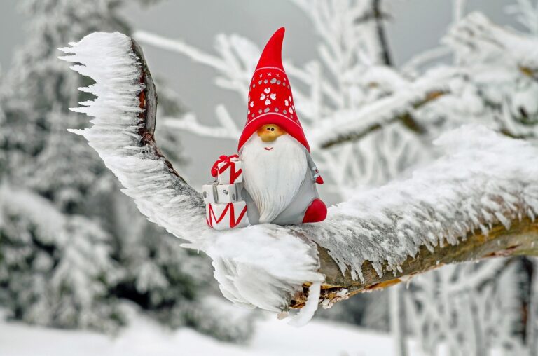 Santa Claus figurine resting on a snowy branch, a festive scene for winter destinations