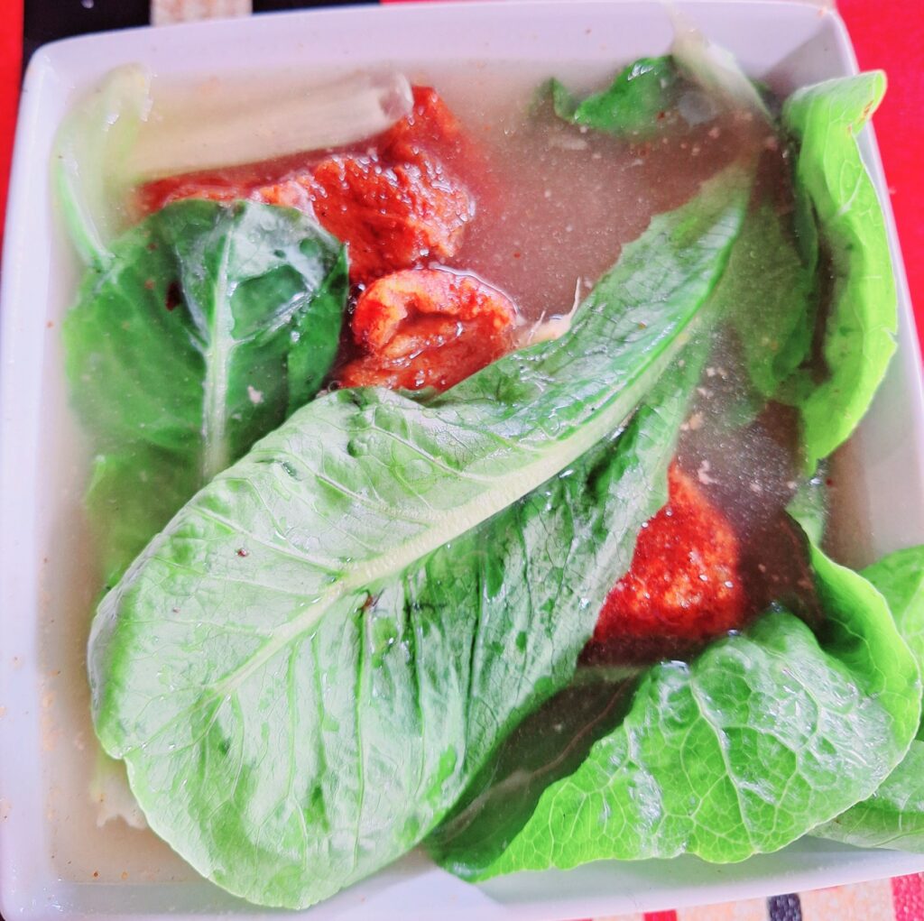 Lechon Kawali Pork Sinigang served at Torogis Restaurant in Baguio City, topped with fresh lettuce