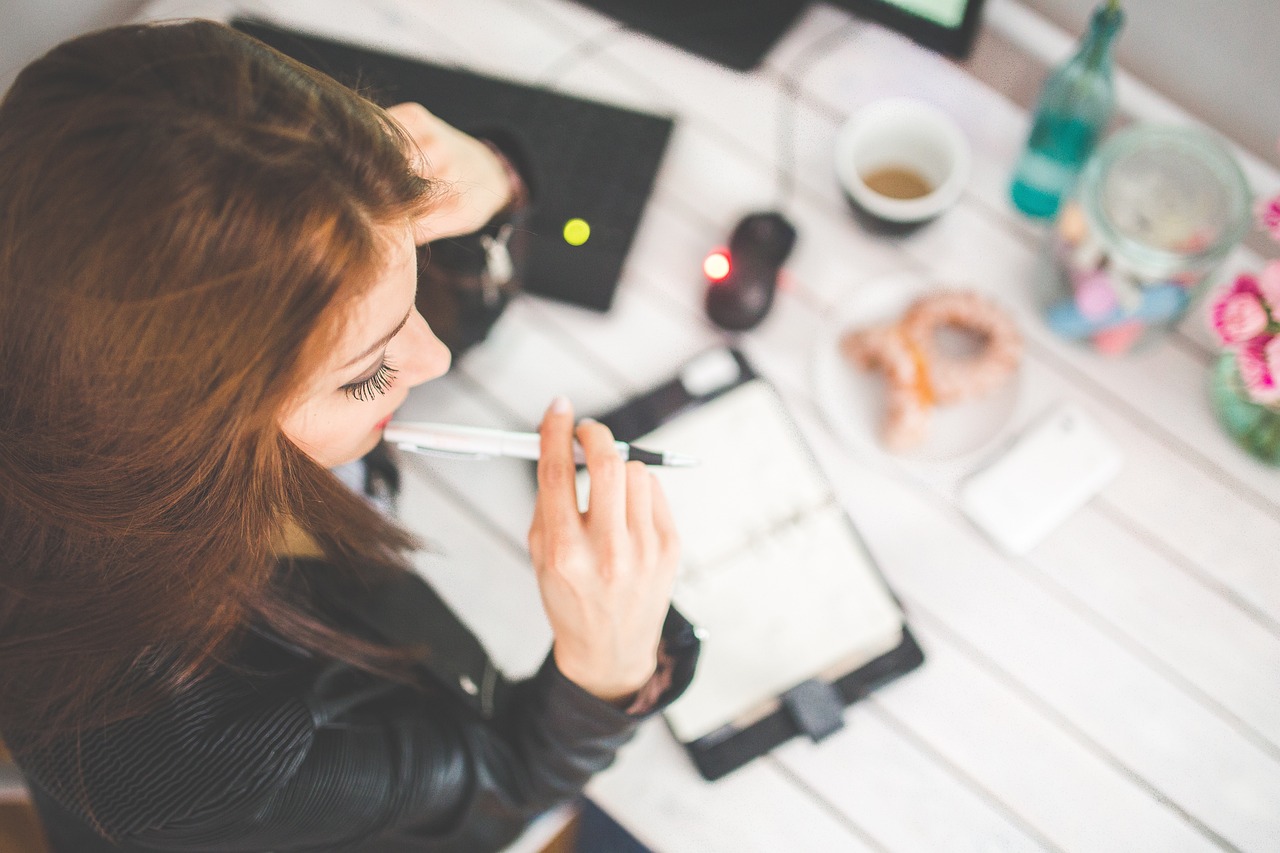 Deep Work in practice – a woman focused at her desk, writing in a notebook